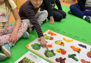 Chłopiec pokazuje ilustracje warzyw
